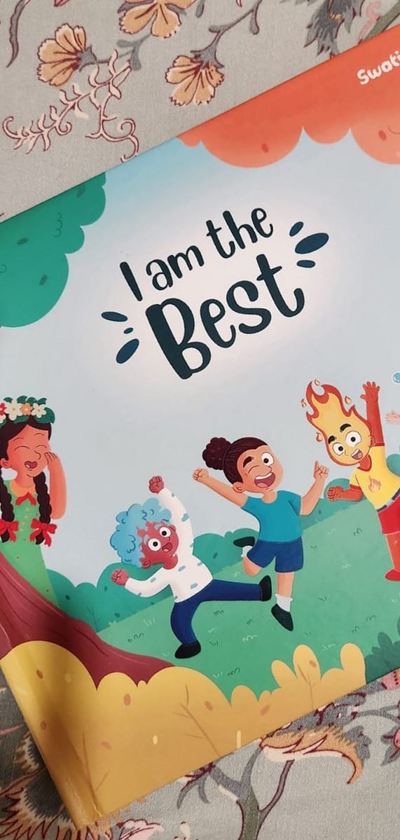 The picture book I Am The Best lying face up on a floral fabric